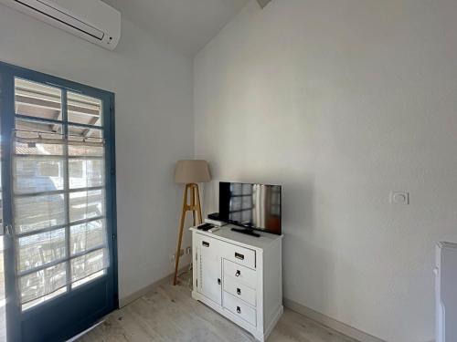 une pièce avec une télévision sur une commode et une fenêtre dans l'établissement Appartement 4 pers avec climatisation et parking privé à Saintes-Maries-de-la-Mer - FR-1-475-191, à Saintes-Maries-de-la-Mer