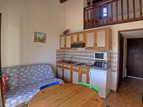 - une cuisine avec un canapé et une table dans une chambre dans l'établissement Appartement 4 pers. avec mezzanine et balcon, stationnement privatif - FR-1-475-194, à Saintes-Maries-de-la-Mer