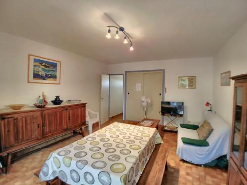 une chambre avec un lit, un canapé et une télévision dans l'établissement Appartement RDC pour 4 pers avec cour et parking proche mer - FR-1-475-196, à Saintes-Maries-de-la-Mer