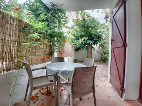 un patio avec une table et des chaises et une clôture dans l'établissement Appartement RDC pour 4 pers avec cour et parking proche mer - FR-1-475-196, à Saintes-Maries-de-la-Mer