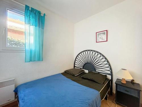une chambre avec un lit bleu et une fenêtre dans l'établissement Appartement 4 pers avec piscine et parking à Saintes-Maries-de-la-Mer - FR-1-475-198, à Saintes-Maries-de-la-Mer