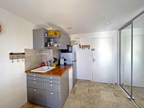 une cuisine avec un évier et un réfrigérateur dans l'établissement Appartement climatisé 4 pers avec parking, proche mer - FR-1-475-203, à Saintes-Maries-de-la-Mer