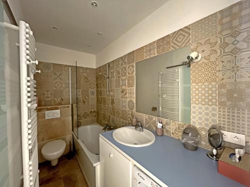 une salle de bain avec un lavabo, des toilettes et un miroir dans l'établissement Appartement climatisé 4 pers avec parking, proche mer - FR-1-475-203, à Saintes-Maries-de-la-Mer