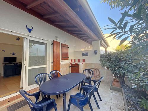 un patio avec une table et des chaises et une cuisine dans l'établissement Appartement 6 pers avec parking - FR-1-475-205, à Saintes-Maries-de-la-Mer