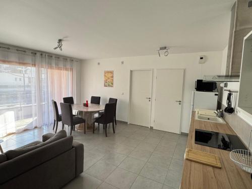 une cuisine et un salon avec une table et des chaises dans l'établissement Spacieux T2 avec terrasses et garage, animaux bienvenus - FR-1-555-111, à Aix-les-Bains