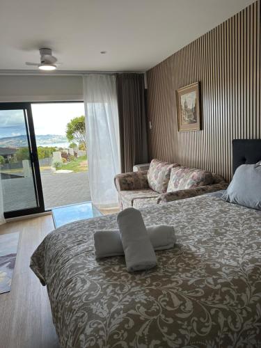 a bedroom with a large bed and a couch at Beautiful Lakeview Apartment in Taupo