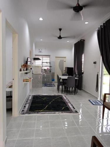 a living room with a table and a dining room at VE Homestay Pasir Puteh in Pasir Puteh