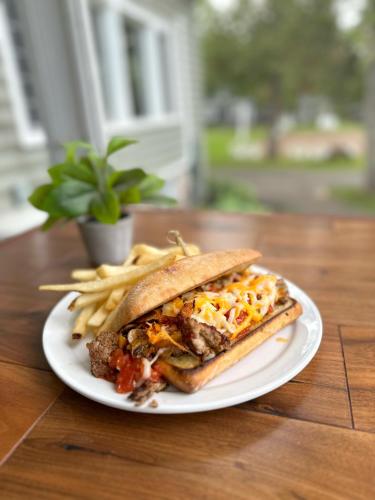 a white plate with a sandwich and french fries at Bonnie View Inn in Haliburton