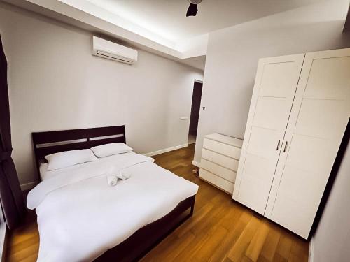 a bedroom with a large white bed and white cabinets at SS KL Sentral by NomadNest in Kuala Lumpur
