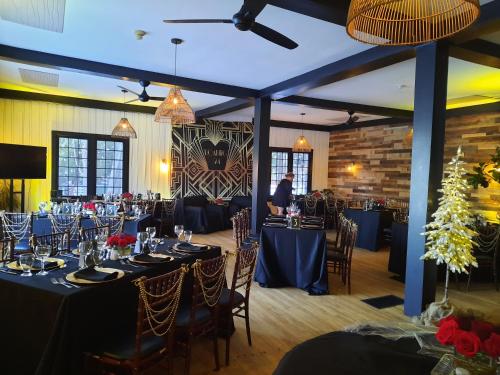 a banquet hall with blue tables and chairs and a man at Bonnie View Inn in Haliburton