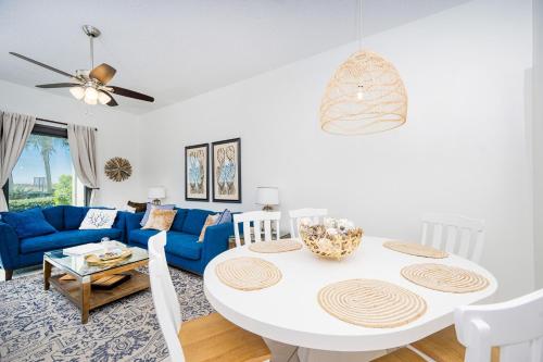 a living room with a white table and a blue couch at Phoenix VII 7015 condo in Orange Beach