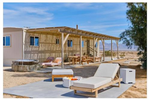 a house in the desert with a table and chairs at Desert Dream Cabin, Healing Mineral Water Tub in Twentynine Palms