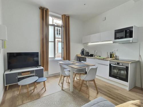 une cuisine avec une table et des chaises dans une pièce dans l'établissement Esprit Cosy - Coeur de Village, à Nègrepelisse