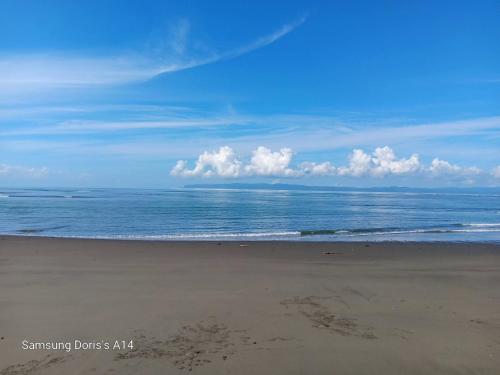 a beach with the ocean and clouds in the sky at Doris&Ted House in Golfito