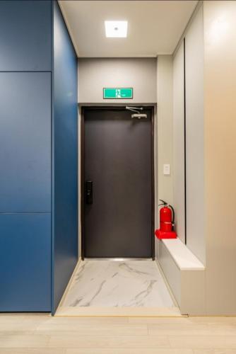 an elevator with a blue door and a red fire hydrant at Brand New Residence with Family in Busan