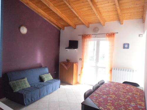 a living room with a blue couch and a table at La Rosa dell'Etna in Castiglione di Sicilia