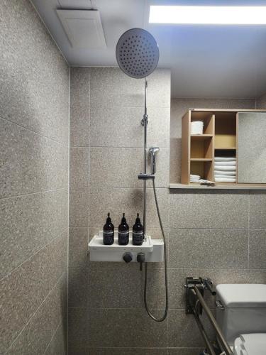 a shower in a bathroom with a sink and a toilet at Brand New Residence with Family in Busan