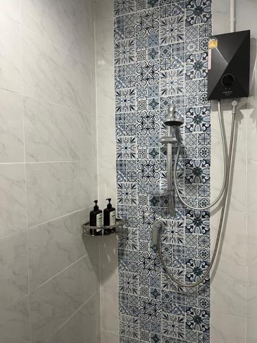 a bathroom with a shower with a tile wall at Baan Saen Saran residence in Sathani Bang Ramat