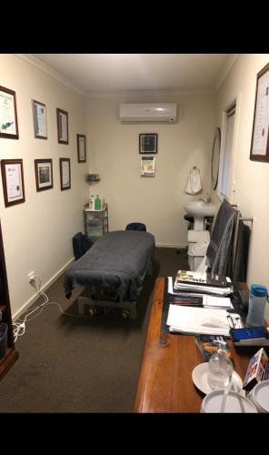a hospital room with a bed and a desk at Unique Zone half house with games room & outdoor jacuzzi in Maiden Gully, Bendigo in Bendigo