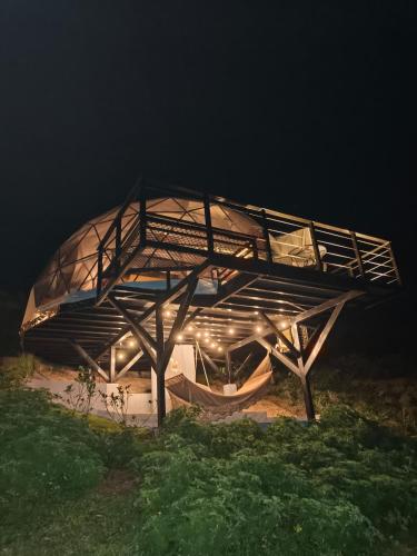 a building with a roof on a field at night at Domo Mágico en las Alturas, EL SOL in San José