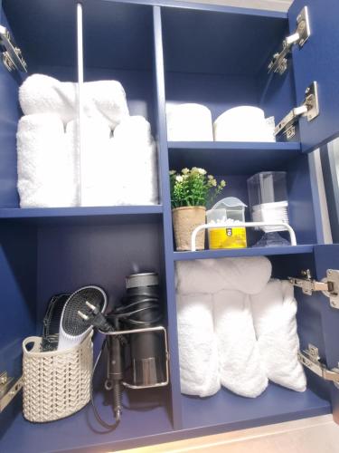 a blue pantry with white towels and a basket at 정스테이 서울 잠실 롯데월드 kspodome 아산병원 길동 코엑스 성수명동강남동대문 in Seoul