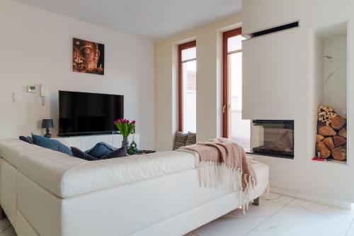 a white living room with a white couch and a fireplace at Exclusive townhouse Maciejki with garden and terrace near Warsaw in Nowa Wola