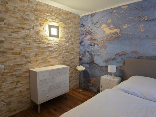 a bedroom with a bed and a brick wall at Marburg Apartment feuriger Felix mit Kamin und Garten in ruhiger Waldrandlage in Marburg an der Lahn