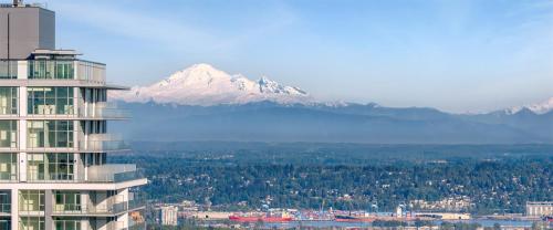 a mountain in the distance with a city and a building at Pacific Sweet Place @Metro in Burnaby