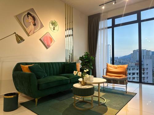 a living room with a green couch and a table at New 2BR Georgetown Warm and Lovely Homestay 10pax-无敌美景两房民宿 Beacon Executive Suite in George Town