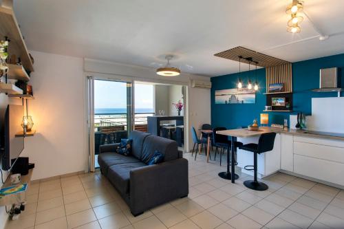 a living room and kitchen with a couch and a table at TI KAZ BONER Vue Mer in Saint-Pierre