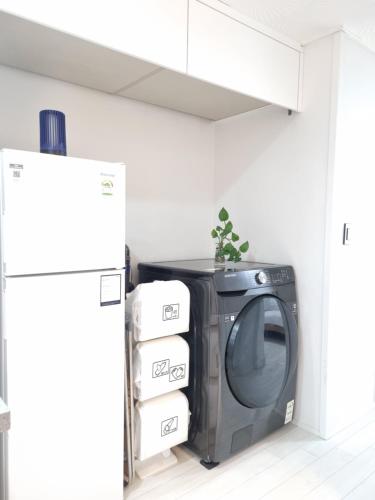 a black television in a room with a refrigerator at 정스테이 서울 잠실 롯데월드 kspodome 아산병원 길동 코엑스 성수명동강남동대문 in Seoul