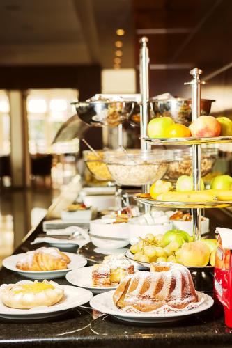 a buffet with plates of food on a counter at Spa & Wellness Hotel Pinia in Malinska