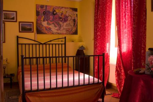 a bedroom with a bed with red curtains at Arco Dei Nobili in Monforte dʼAlba