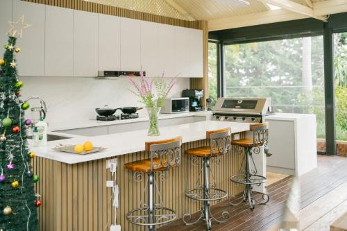 a kitchen with a christmas tree and a kitchen with white cabinets at zhus garden in Kilsyth