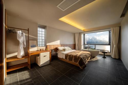 a hotel room with a bed and a large window at Erhai Seaview Garden Villa &Dali Airport in Dali