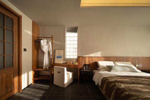a bedroom with a bed and a desk and a window at Erhai Seaview Garden Villa &Dali Airport in Dali