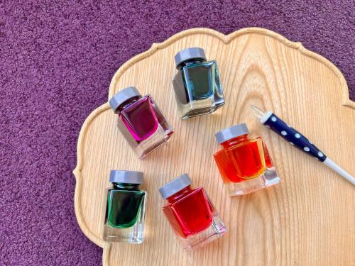 a wooden cutting board with four bottles of paint at Wataya Besso in Ureshino