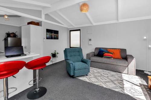 a living room with a couch and a chair at Cottage on Churchill in Whangarei