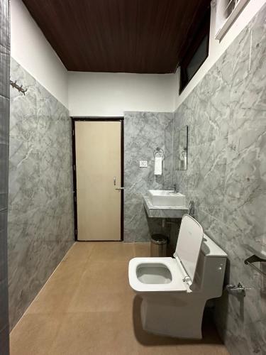 a bathroom with a toilet and a sink at Zen Resort Shergaon in Shergaon