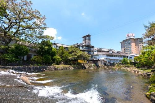 a river in a city with buildings in the background at Wataya Besso in Ureshino