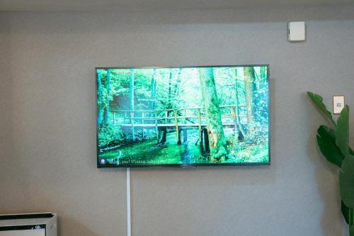 a flat screen tv hanging on a wall at Tokyo Base Meguro Room #301 in Tokyo