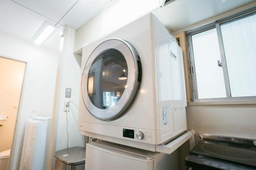 a washing machine in a room with two windows at Tokyo Base Meguro Room #301 in Tokyo