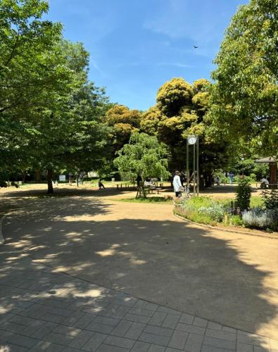 a person walking down a path in a park at Tokyo Base Meguro Room #301 in Tokyo