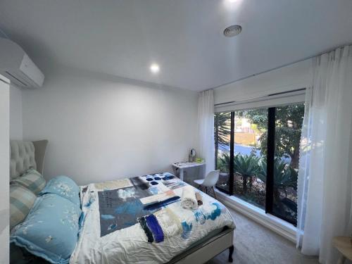 a bedroom with a bed and a large window at Premium Snooze Queen Bed Petite Room in Caroline Springs