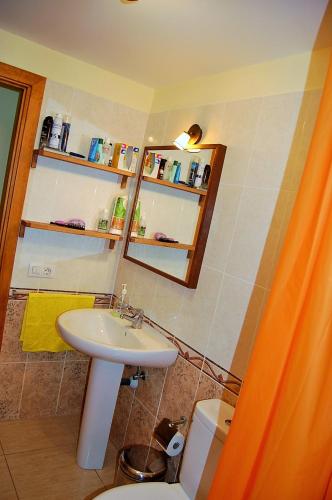 a bathroom with a sink and a toilet and a mirror at Casa Innès in Punta Mujeres