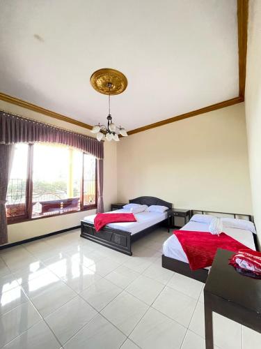 a bedroom with two beds and a large window at NN Homestay in Tlekung