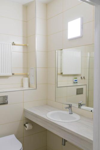 a bathroom with a sink and a mirror at Hotel Mazury in Giżycko