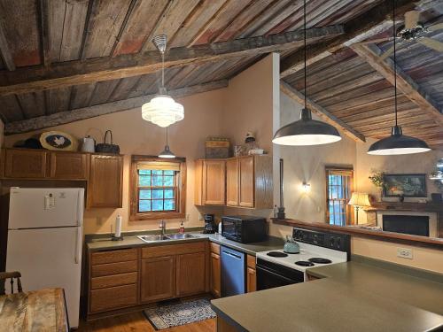 a kitchen with wooden cabinets and a white refrigerator at Chanticleer Cabins in Sturgeon Bay