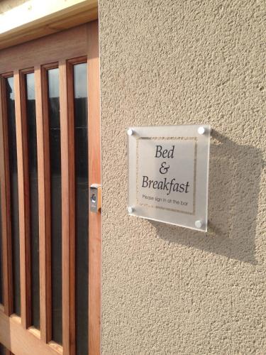 a sign for a bed and breakfast on the side of a building at The Wheatsheaf in Crick