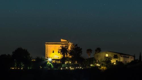 a building at night with lights in front of it at Hotel Foresteria Baglio Della Luna in San Leone
